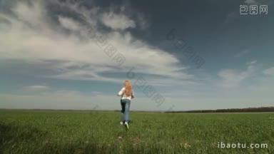 快乐的金发小女孩在春天的田野上奔跑