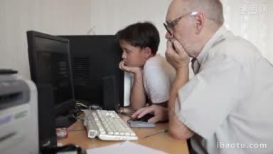 <strong>爷爷</strong>在电脑上工作，男孩在看屏幕