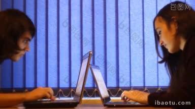 两个人用笔记本电脑打字