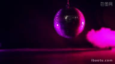 圆形镜面银色迪斯科球反射紫色的光在黑暗中充满烟雾的气氛在娱乐场所