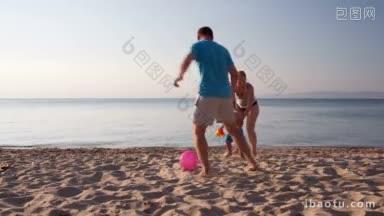 年轻的家庭在一起嬉戏踢足球，在日落的海滩上，小男孩和他的妈妈一起跑步