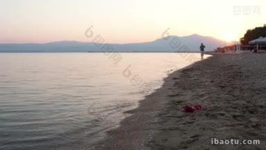 黎明时分，一名男子在热带海滩上奔跑，太阳在他身后，当他接近照相机时