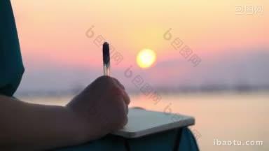 <strong>近</strong>距离的观点，一个女人的手写在她的日记在日落与发光的球体