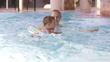 母亲笑着和她的小儿子在游泳池里玩耍，孩子正在学习游泳