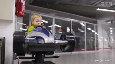 小男孩在室内商场或汽车陈列室里驾驶高架模型赛车