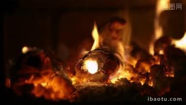 在壁炉里燃烧木柴的特写镜头，用手往火里<strong>添加</strong>钢坯