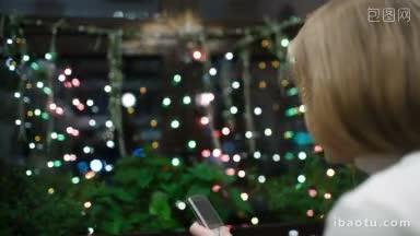 闪烁的圣诞花环与下面的重点讲电话的女人