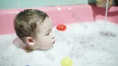 小男孩坐在水与泡沫在他的晚上洗澡水倾泻和<strong>玩具</strong>漂浮