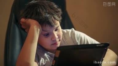 多莉拍摄的男孩使用平板<strong>电脑坐在</strong>桌子<strong>前</strong>