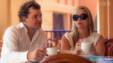 一对年轻夫妇在咖啡馆露台上<strong>喝茶聊天</strong>