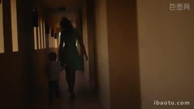 母子沿着酒店大厅走男孩从妈妈身边跑开