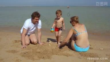 幸福的一家三口在沙滩上妈妈和爸爸堆沙堡