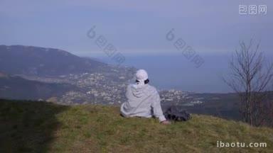 女徒步旅行者在雅尔塔的山顶上<strong>休息</strong>，欣赏风景