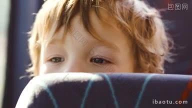 一个小男孩在<strong>公交车</strong>上的特写镜头，他的半张脸藏在座位后面