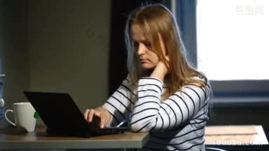 一个年轻的女人在家里用笔记本电脑工作，她<strong>喝茶</strong>，看起来专注和疲惫