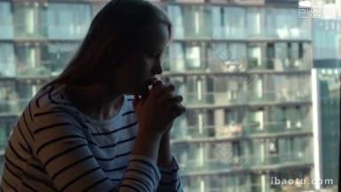 孤独的悲伤女人，手贴脸坐在窗边，带着现代都市的风景，在<strong>大城</strong>市里孤独