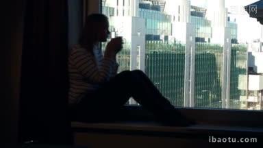 年轻女子坐在窗台上，<strong>端着</strong>一杯茶或咖啡，欣赏<strong>着</strong>城市的全景