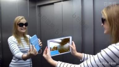 年轻女子在电梯里用触摸板用镜子给自己拍有趣的照片
