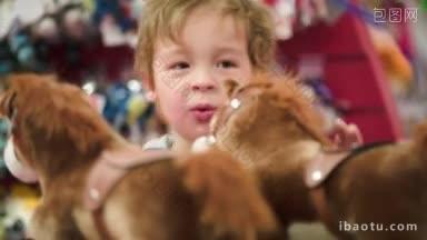 一个可爱的小男孩看着玩具店里柔软的玩具马