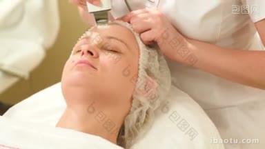 一个女人在美容水疗中心<strong>接受</strong>超声波面部治疗的倾斜镜头