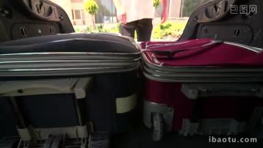 男子旅客正从汽车行李箱中拿出折叠式行李
