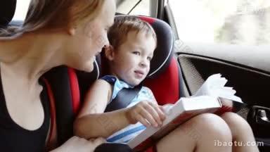 母亲和儿子说话时，他们<strong>乘车</strong>旅行，男孩拿着打开的书坐在儿童安全座椅上