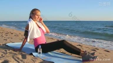 健身运动的妇女在无线耳机放松锻炼后，在海滩上听<strong>音乐</strong>从智能手机mp<strong>播放器</strong>