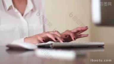 年轻的女商人在办公室的<strong>电脑</strong>上工作，敲击<strong>键盘</strong>和鼠标写电子邮件