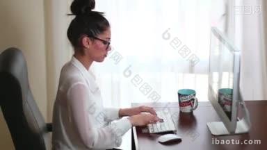 年轻的女商人在办公室的电脑上工作，敲击<strong>键盘</strong>和鼠标写电子邮件