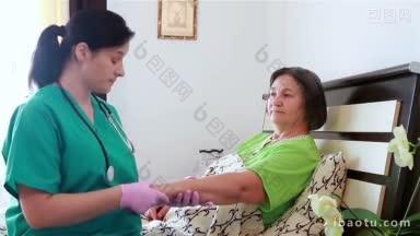 在敬老院，护士为<strong>受伤的</strong>老年妇女手臂包扎，把注意力集中在病人身上