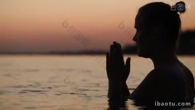 日落时分在海上祈祷或冥想的<strong>女人</strong>