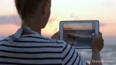 一位妇女在日落时用平板电脑拍摄波涛<strong>汹涌</strong>的<strong>海浪</strong>