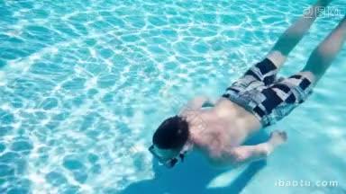 一名少年浮在游泳池的水下