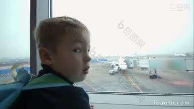 小男孩看着窗外的机场，指着飞机起飞跑道