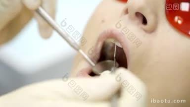 微距拍摄的牙医<strong>检查</strong>妇女的牙齿，她戴着红色的安全眼镜