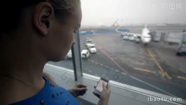 在机场，一位女士一边用智能手机听音乐一边看着窗外