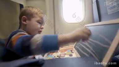 小男孩在<strong>飞机</strong>上用粉笔在小木板上<strong>画画</strong>，在飞行中娱乐