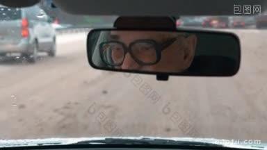 冬天在城市里开车，戴眼镜的老人在杂乱的道路上开车