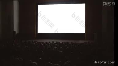 观众在黑暗的电影院大厅前的大空白屏幕获得新的印象和放松