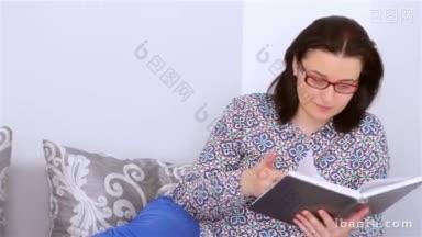 <strong>戴眼镜</strong>的年轻女人坐在沙发上看书