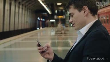 年轻的商人在地下坐着，一边等火车一边发短信
