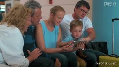 幸福的一家人在机场聊天，用平板电脑娱乐