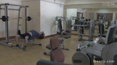 现代健身房的人锻炼与重量磁盘和另一个人工作在<strong>拉下</strong>机在镜子反射的观点