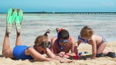 在呼吸管潜水后休息时，父母和儿子在海滩上玩沙子