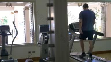 慢动作的一个人训练在跑步机上的轻便和现代化装备的健身房有氧机保持他的健康