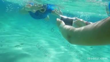 慢动作的两个人潜水，以获得良好的水下照片，妇女使用智能<strong>手机</strong>在<strong>防水</strong>的情况下拍照