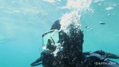 慢动作镜头的潜水员呼吸下的水，他正在呼气和气泡<strong>出现</strong>在他的周围