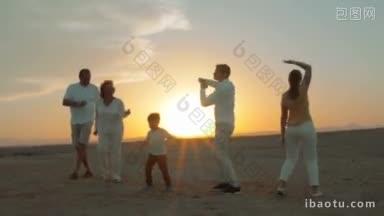 斯坦尼康拍摄<strong>的</strong>一大家子人在日落时在海滩上<strong>跳舞</strong>