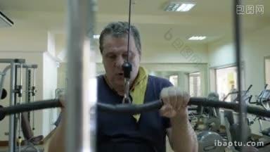 健身在现代化设施的健身房，成熟的男人在拉下健身器上锻炼