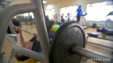 慢动作的一个人正在做卧推运动，在健身房的力量训练变得更强壮